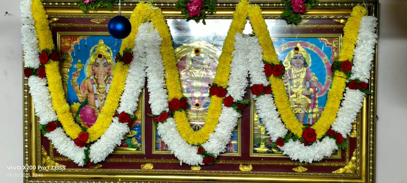 Garlanded framed deity pictures on the office altar during the Dussehra pooja